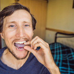 Invisalign patient in Minot putting aligners in at home