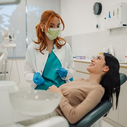 Dentist talking to smiling patient in treatment chair
