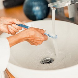 Woman rinsing her toothbrush