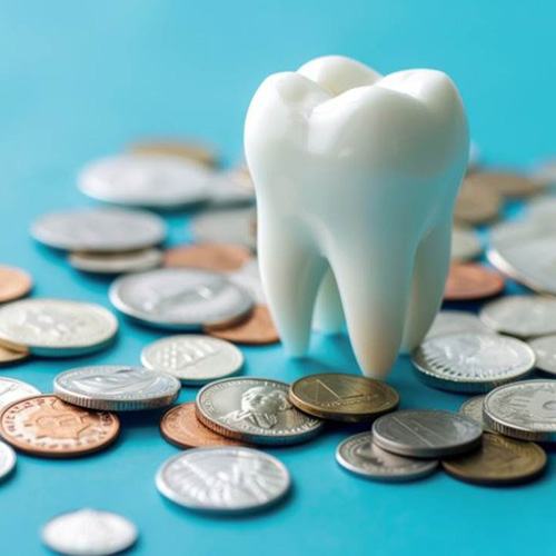 a model of a tooth surrounded by coins