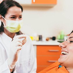 a dentist holding a patient’s extracted tooth