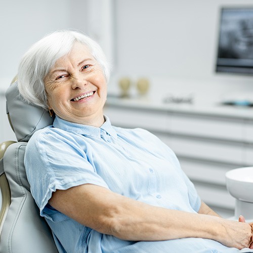 Senior woman sitting in dental chair and smiling