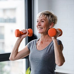 Closeup of woman smiling while lifting weights