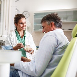 Smiling dentist talking to patient during dental checkup